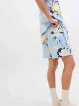 Short de baño celeste con estampado de flores blancas, amarillas y verdes. Tiene cintura elástica con cordón ajustable, bolsillos laterales y logo de la marca en la pierna derecha.