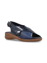 Sandalias color beige con tiras cruzadas en la capellada, una tira color dorado y otra color beige. Tiene una tira trasera con hebilla para ajustar al tobillo y suela baja.