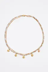 Collar doble de cadena dorada, uno con cuentas de colores y otro con dijes de monedas.