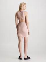 Vestido corto de punto milano color rosa pálido, de corte ajustado y sin mangas. Presenta espalda deportiva con panel recortado, cremallera lateral oculta y logo monograma de Calvin Klein estampado en el pecho.