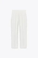 Pantalón capri blanco de tiro alto con bolsillos delanteros de vivo y cierre frontal con cremallera, botón interior y gancho metálico.