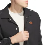 Campera Adidas negra con cierre de botones a presión, cuello clásico, bolsillos laterales y logo de la marca bordado en color naranja en el pecho. Presenta ribetes blancos en cuello, puños y mangas.