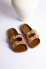 Sandalias marrones de gamuza con doble tira y hebillas doradas ajustables.