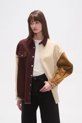 Sobrecamisa de pana con diseño color block en tonos marrón oscuro, beige y camel. Presenta cuello camisero, botones frontales, un bolsillo de parche en el pecho izquierdo y bordes deshilachados en el ruedo y puños.