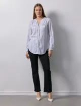 Blusa de lino a rayas verticales blancas y grises, marca Zac & Rachel. Tiene cuello a la base, escote en V y abertura central con botones. Cuenta con dos bolsillos en el pecho y mangas largas regulables con presilla y botón.