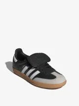 Zapatillas Adidas Samba LT, color negro con las tres tiras blancas y suela de goma marrón.