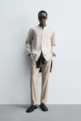 Camisa negra de lino y algodón, corte relaxed fit, cuello mao, manga larga con puños abotonados y cierre frontal con botones.