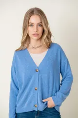 Cardigan celeste de lana con escote en V y botones marrones.