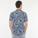 Remera polo de piqué de algodón color azul con estampado de hojas en blanco y negro.