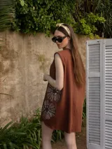 Vestido corto gris con bordado floral en el frente, corte holgado y mangas cortas.