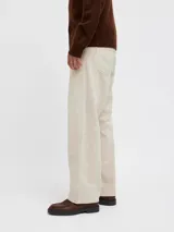 Pantalón de jean color beige, de corte amplio y tiro alto. Diseño clásico de cinco bolsillos y cierre con botones.