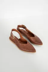 Zapato chata de cuero color marrón con textura tejida y hebilla dorada.