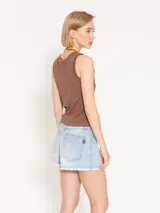 Short de jean celeste de tiro medio, corte clásico y calce relajado. Tiene roturas y ruedo desflecado.