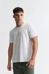 Remera blanca con estampado abstracto en tonos grises, de manga corta, corte regular y cuello redondo.