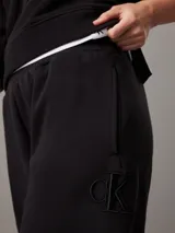 Pantalón de chándal negro de felpa de mezcla de algodón reciclado, corte regular, cintura elástica con cordón interior, puños de punto, bolsillos en la costura lateral y bordado en relieve Calvin Klein en la parte superior de la pierna.