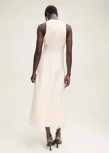 Vestido midi evasé color blanco hueso, sin mangas y cuello halter. Confeccionado en tejido mezcla de lino.