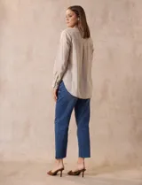 Blusa beige de lino y rayón, marca Dash. Tiene cuello a la base, escote en V y abertura con botones. Delantera con bolsillos. Largo de manga regulable con presilla y botón.