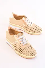 Zapatillas acordonadas color dorado con capellada de cuero calado, detalles en cuero liso y suela de goma.