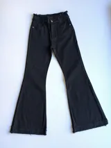 Pantalón de jean negro, de corte semioxford, con cintura alta y botón plateado.