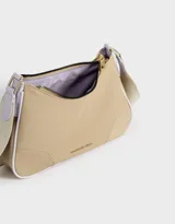 Bandolera color beige con correa blanca regulable y desmontable, tag frontal en relieve y cierre superior.