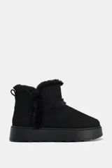 Botín negro con interior de efecto pelo, suela tipo flatforma y acabado en punta redonda.