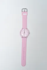 Reloj analógico con correa de silicona color rosa pálido y esfera blanca con números negros.