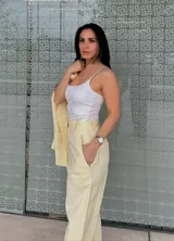 Pantalón de vestir amarillo con finas rayas verticales blancas, corte recto, tiro alto y bolsillos laterales.