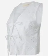 Chaleco blanco de algodón con bordado calado tipo laise, escote en pico y cierre frontal con lazos.