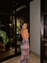 Vestido largo de microtul con estampado floral, escote en V profundo con borde de encaje negro y espalda descubierta con tirantes finos ajustables.
