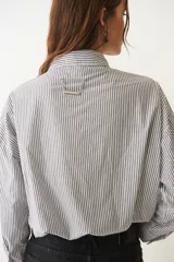 Camisa corta negra de algodón, de corte holgado, con cuello camisero y abotonada al frente.