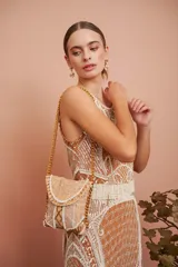 Vestido corto color ocre con bordado de motivos geométricos en color crema. Sin mangas, con cuello redondo y corte ajustado. Largo a la rodilla.