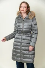 Campera larga gris con capucha con borde de piel sintética, cierre frontal con cremallera, cinturón ajustable y diseño acolchado.