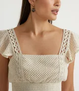 Blusa musculosa cropped color crudo, de algodón texturizado, con escote cuadrado, tirantes anchos con volantes y lastex en el dobladillo.