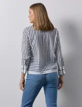 Blusa de gasa estampada a rayas verticales blancas y negras, marca Sioni. Espalda con abertura y botón. Manga larga con puño y botón.