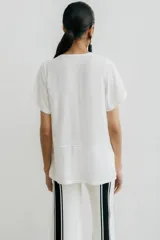 Remera blanca con corte horizontal y parte inferior negra. Cuello en V y mangas cortas.