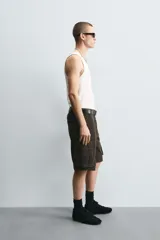 Bermuda cargo de algodón color marrón oscuro, tiro medio, corte regular, con bolsillos laterales de parche con solapa y bolsillos traseros de vivo.