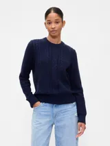 Buzo de algodón color azul marino, con cuello redondo y diseño de punto trenzado en el frente.