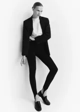 Calza fuseau negra de tejido elástico con costuras decorativas, tiro alto y cintura con goma elástica.