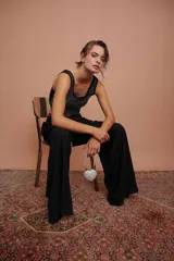 Body negro con escote redondo y apliques de strass plateados en el frente. Presenta corte cut-out en los laterales y cierre con lazos.