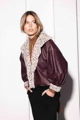 Campera corta de cuerina color bordó con cuello y puños de piel sintética con estampado animal print. Mangas largas abullonadas y corte holgado.