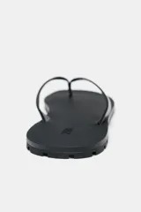 Sandalia plana de piel color negro, con tiras delanteras y suela de goma.