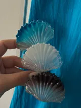 Broche con forma de concha marina en color azul, blanco y marrón.