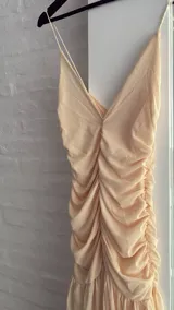 Vestido largo color amarillo pastel, con breteles finos y escote en V. La parte superior es de doble tela de microtul y la falda es amplia con volados.