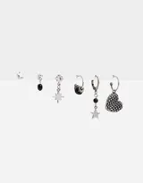 Set de aros plateados con distintos pasantes y argollas con dijes de estrella, corazón y cuentas negras.