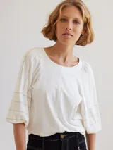 Remera blanca de algodón con mangas abullonadas y pespuntes en color crudo.