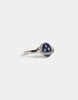 Anillo plateado con diseño de planeta esmaltado en azul y estrellas plateadas.