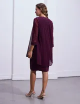 Conjunto de fiesta RM Richards de dos piezas color violeta. Vestido al cuerpo de lurex con cuello redondo y apliques de brillos. Chaqueta de microtul con mangas 3/4.