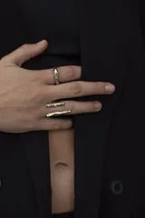 Anillo plateado con diseño abstracto y abierto, realizado en alpaca.