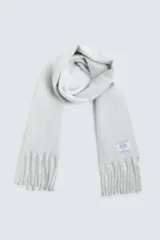 Bufanda rectangular color crema con flecos en los extremos, confeccionada en tejido con textura cepillada.