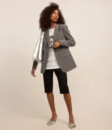 Blazer gris de poliéster, viscosa y elastano, de corte alargado, con cuello con solapas, bolsillos y cierre frontal con botones.